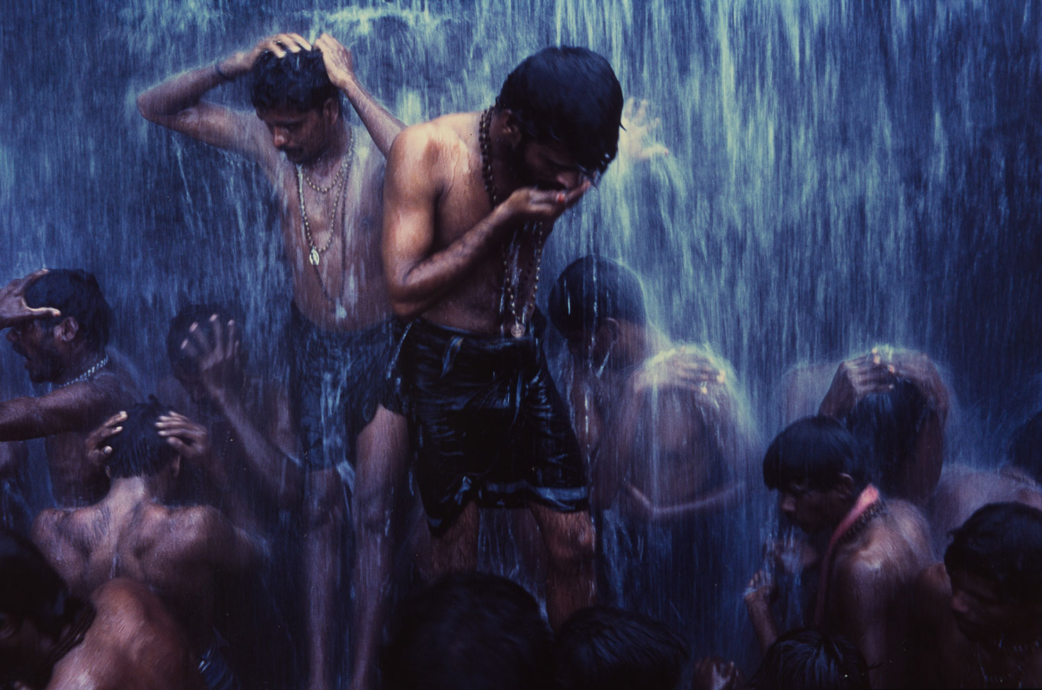 <Shiva devotees ritually bathe under a waterfall at Courtalam, Tamil Nadu, India, 1996, 1996